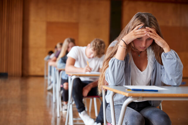 Anxious,Teenage,Student,Sitting,Examination,In,School,Hall (Demo)